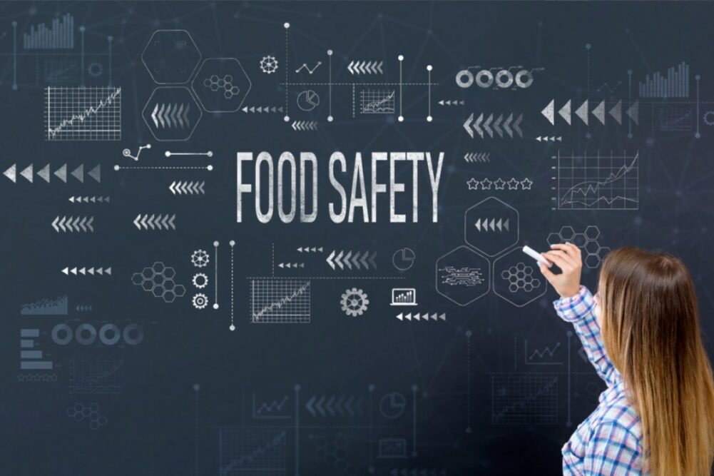 Girl writing "FOOD SAFETY" on chalkboard