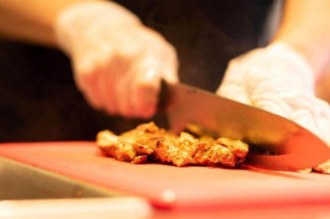 Worker chopping chicken