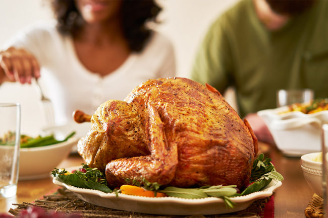 Fully cooked turkey at center of dinner table