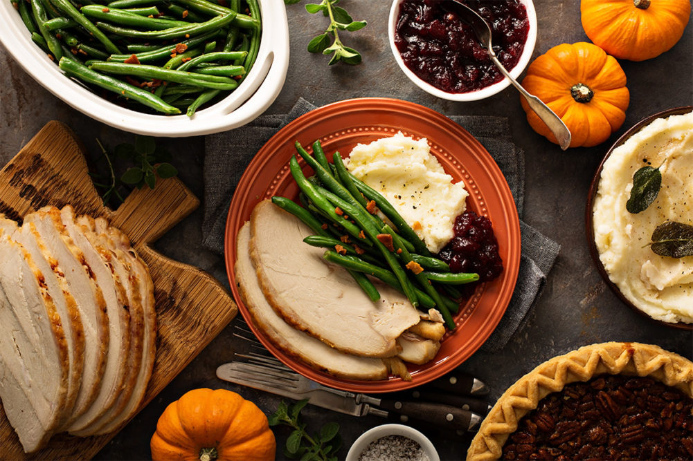 Thanksgiving meal with turkey, green beans, potatoes, and cranberry sauce